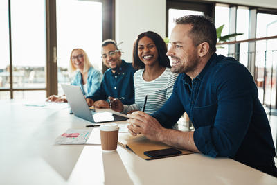 A meeting with 2 men and 2 women around one side of a table