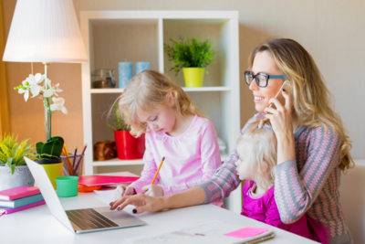 Image of mother with two children while working at home
