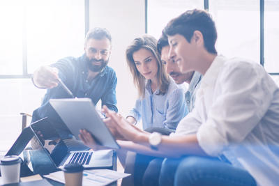 Four work colleagues collaborate as they sit around a table together