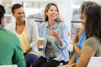 Photo of people talking and smiling over a coffee