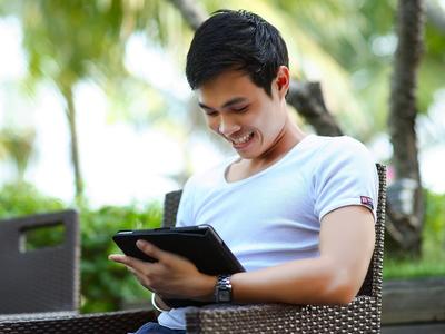 Man looking at screen happy he has a new job