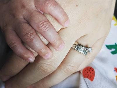 Rebecca Buggs holds her baby son's hand