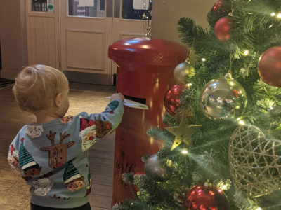Image of Becky's child posting a Christmas letter in a postbox