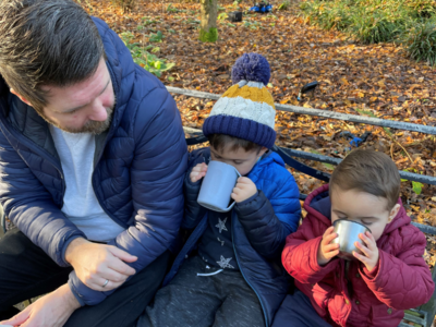 Background is an image of John Crichton, our Head of Solutions Delivery with his two boys who are enjoying hot drinks on a winter day.