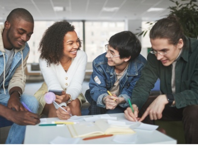 Group of people talking and smiling in the workplace.