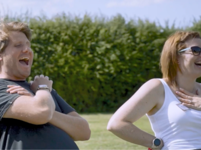 Photo of colleagues laughing at an event in the sunshine