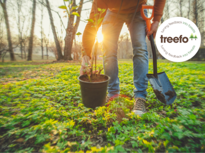 A person planting a tree with the Treefo Sticker in front