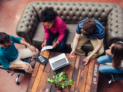 People sat around a table with a laptop