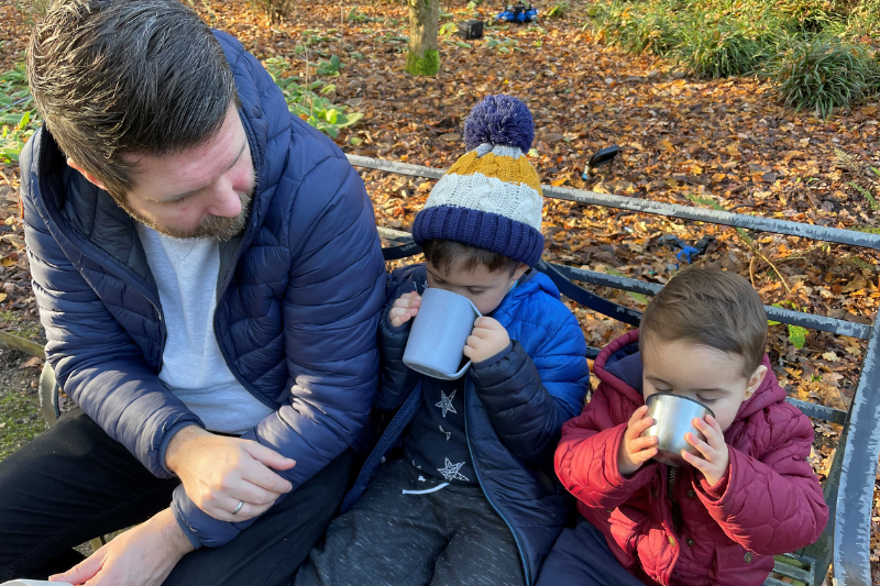 Background is an image of John Crichton, our Head of Solutions Delivery with his two boys who are enjoying hot drinks on a winter day.